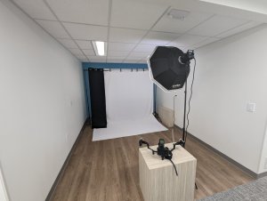 Photography setup in a professional studio with a backdrop, lighting, and camera on a tripod